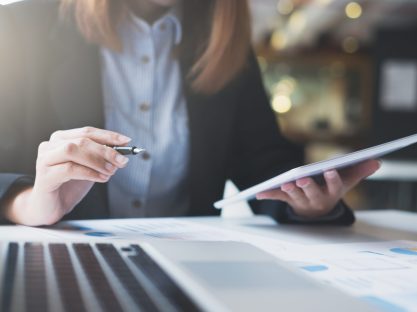 Businesswoman hold pen and works on the digital tablet analyse online infomation.
